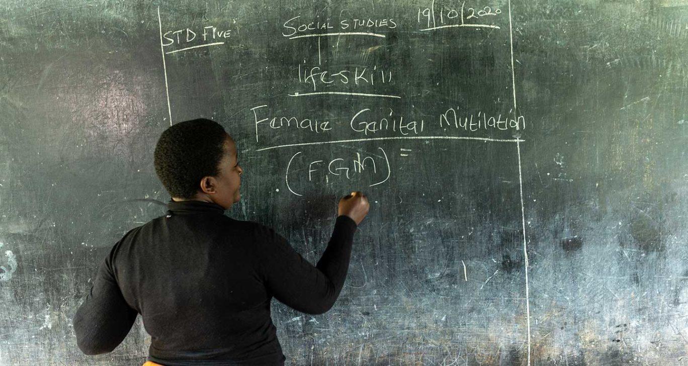 Opettaja Keniassa kirjoittaa liitutaululle.