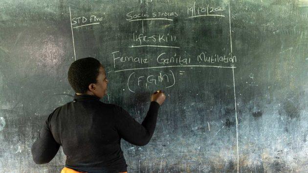 Opettaja Keniassa kirjoittaa liitutaululle.