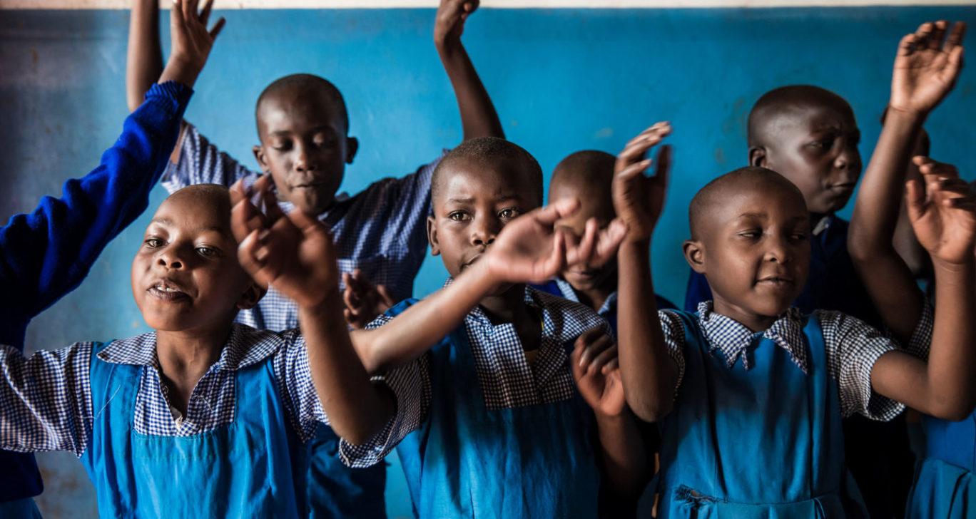 Lapset laulavat silpomisen vastaista laulua turvaleirillä Keniassa.