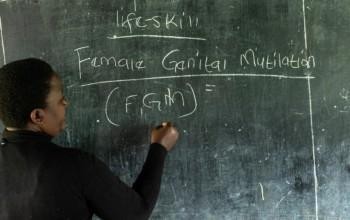 Nainen kirjoittaa Female Genital Mutilation liitutaululle