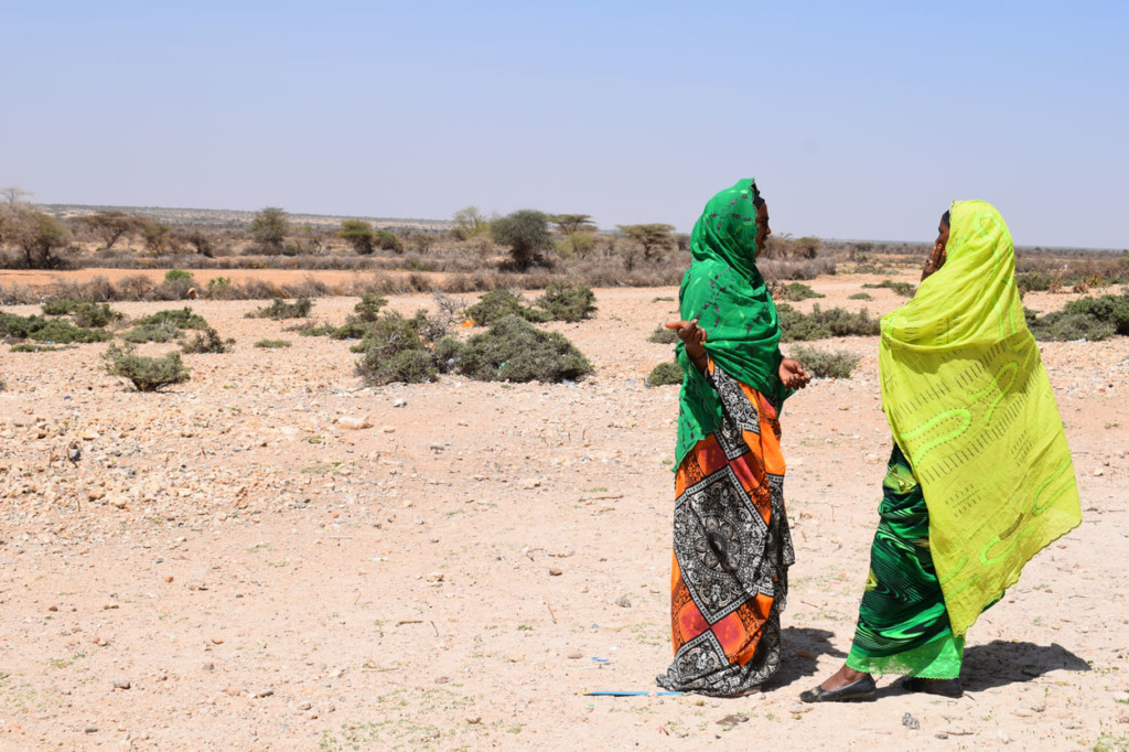 Kaksi naista seisoo aavikolla keskustelemassa