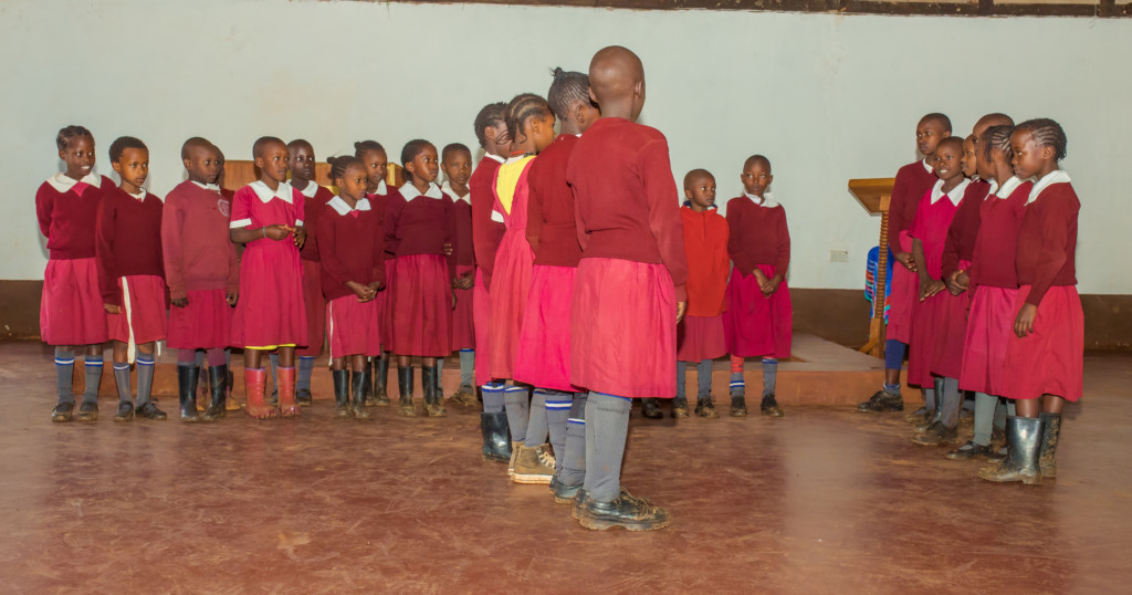 Kuvassa joukko tyttöjä Kenian Kisiissä esittää koulun kerhossa oppimaansa laululeikkiä